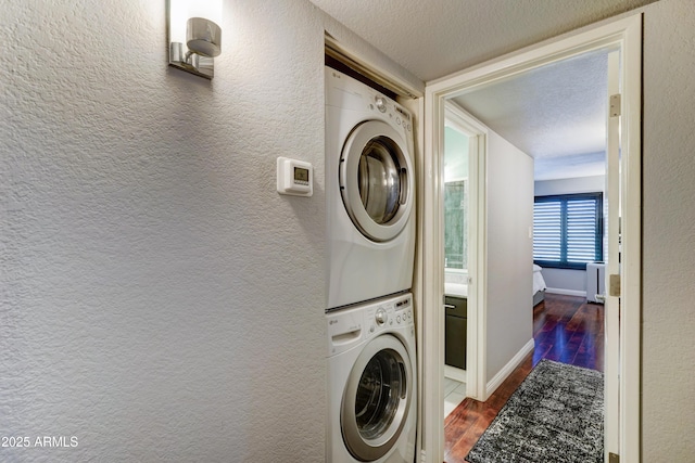 5122 E Shea Blvd Unit 1020, Scottsdale, AZ 85254 - washroom featuring a textured ceiling, dark wood-type flooring, a textured wall, and stacked washing maching and dryer
