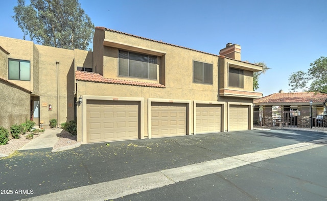 5122 E Shea Blvd Unit 1020, Scottsdale, AZ 85254 - view of front of property with stucco siding, fence, a chimney, and a tiled roof
