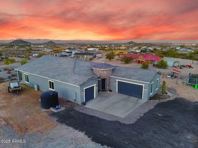 single story home with a garage, a mountain view, concrete driveway, and stucco siding