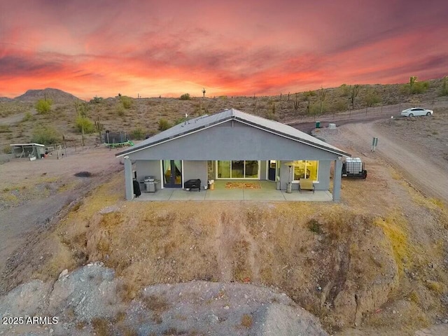 view of front of house with a patio area, a mountain view, and cooling unit