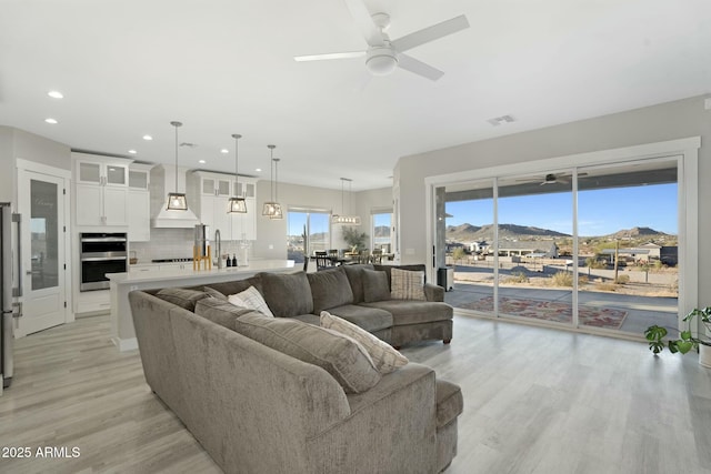 living area with light wood finished floors, visible vents, a ceiling fan, and recessed lighting