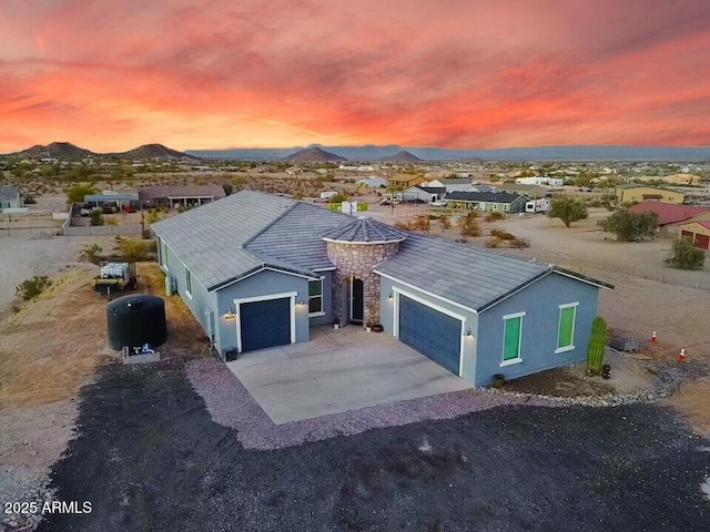 single story home with a garage, driveway, a mountain view, and stucco siding