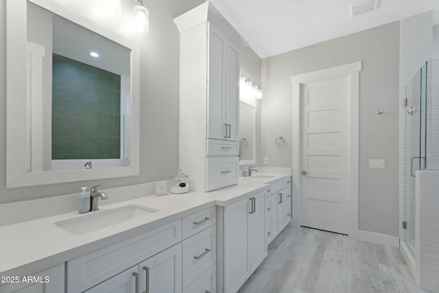 full bathroom featuring a stall shower, visible vents, a sink, and double vanity