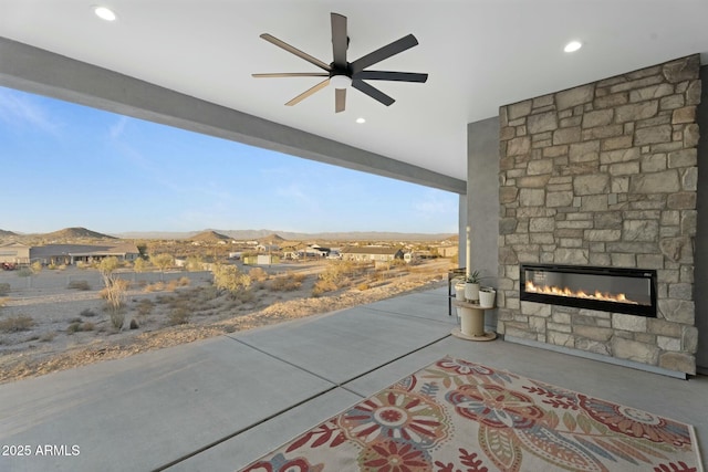 view of patio / terrace with an outdoor stone fireplace and ceiling fan