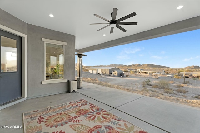 view of patio featuring ceiling fan and a mountain view