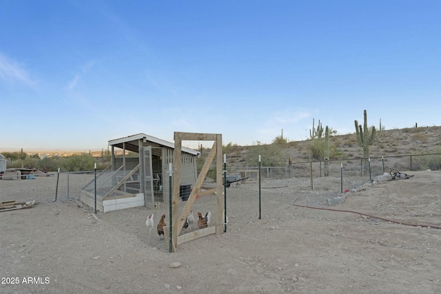 view of jungle gym featuring fence, exterior structure, and an outbuilding