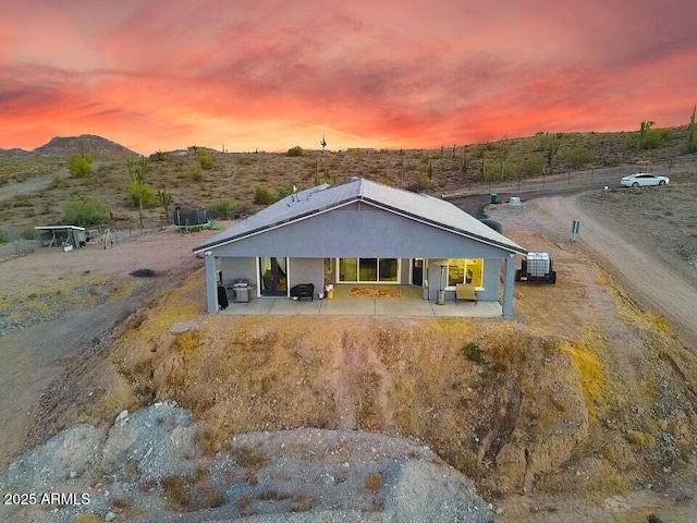 view of front of home with a patio and a mountain view