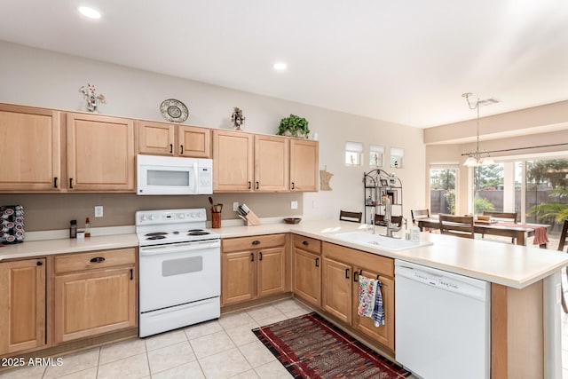 kitchen featuring kitchen peninsula, white appliances, sink, an inviting chandelier, and hanging light fixtures