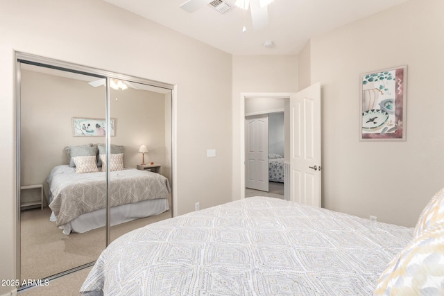 carpeted bedroom featuring ceiling fan and a closet