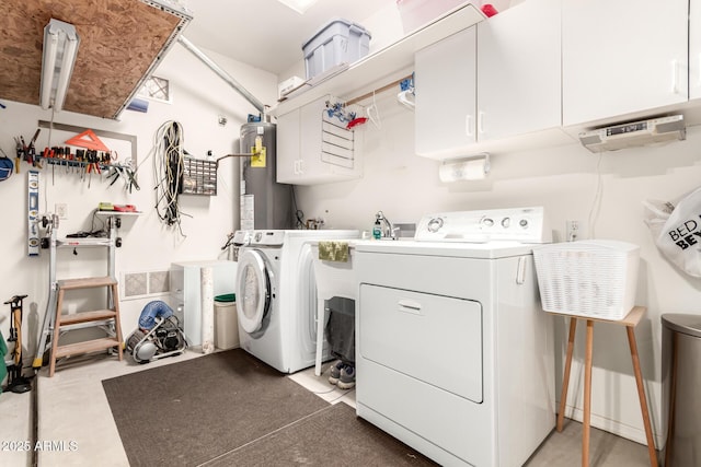 laundry area with washer and clothes dryer, cabinets, and gas water heater