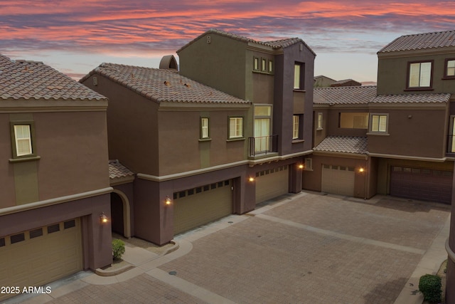 3935 E Rough Rider Rd Unit 1033, Phoenix, AZ 85050 - view of front of house featuring a tile roof, stucco siding, driveway, and a garage