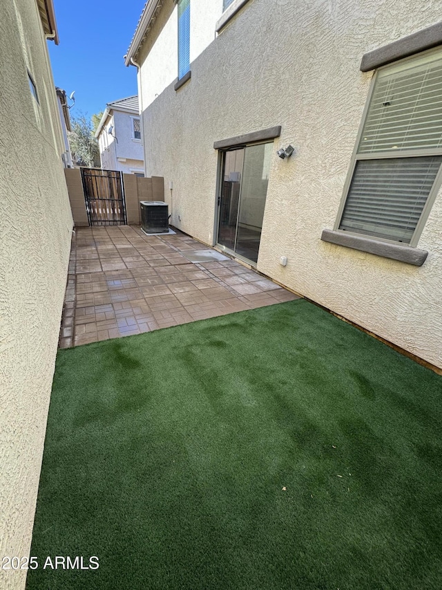 back of property featuring a patio, central AC, and a lawn