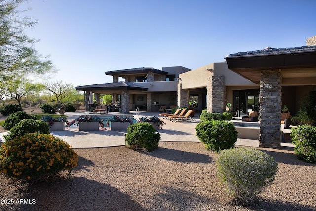 10205 E Happy Valley Rd, Scottsdale, AZ 85255 - rear view of property featuring a patio, stucco siding, a covered pool, and stone siding