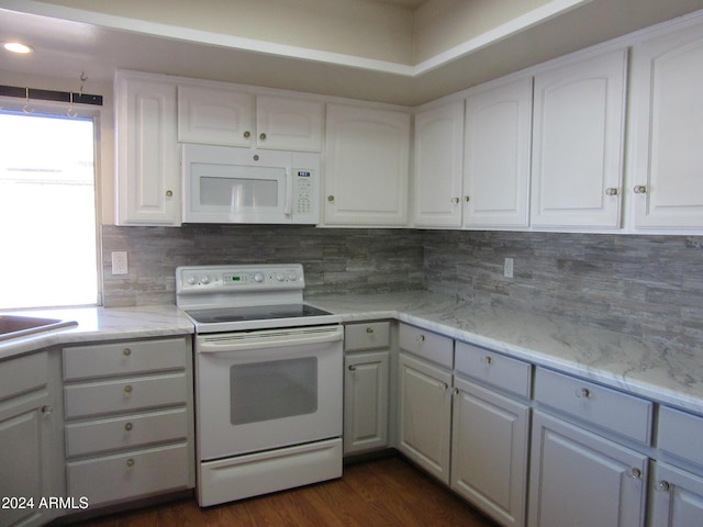 kitchen featuring dark hardwood / wood-style floors, white cabinetry, decorative backsplash, and white appliances