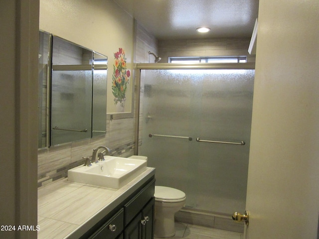 bathroom featuring walk in shower, tasteful backsplash, tile patterned flooring, toilet, and vanity