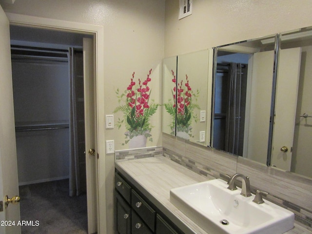 bathroom with vanity and tasteful backsplash