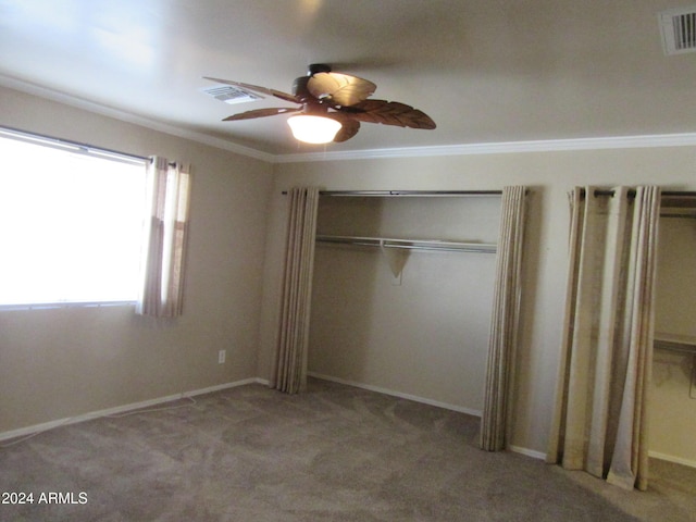 unfurnished bedroom featuring ceiling fan, a closet, light carpet, and ornamental molding