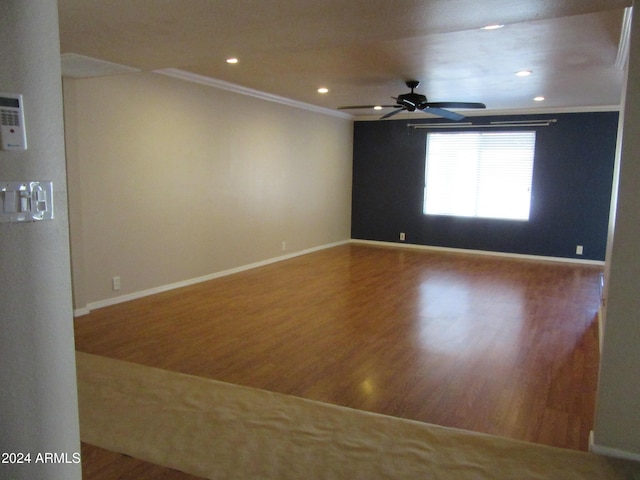 empty room featuring hardwood / wood-style flooring, ceiling fan, and crown molding