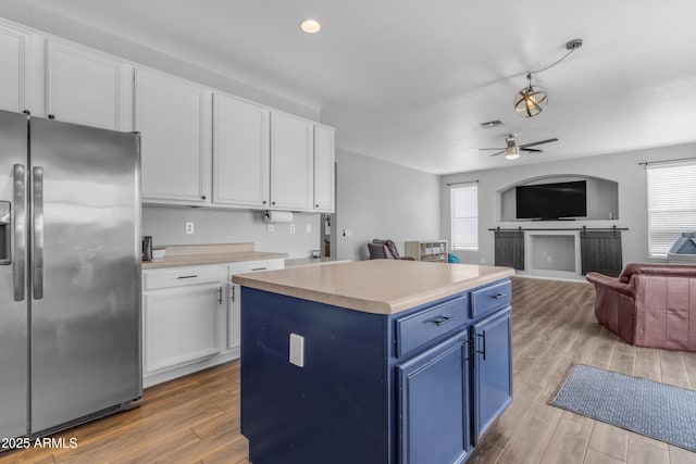 1405 S Honeysuckle Cir, Gilbert, AZ 85296 - kitchen with stainless steel fridge, blue cabinetry, healthy amount of natural light, white cabinets, and recessed lighting