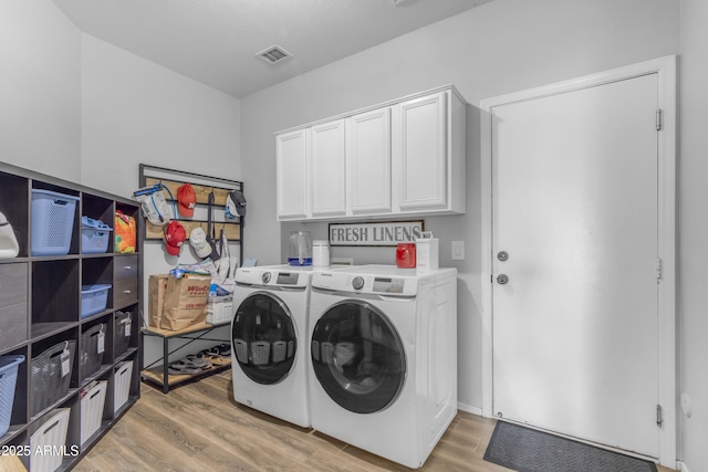 1405 S Honeysuckle Cir, Gilbert, AZ 85296 - laundry area featuring washing machine and clothes dryer, light wood-style flooring, and cabinet space