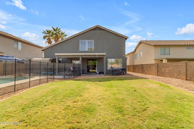 1405 S Honeysuckle Cir, Gilbert, AZ 85296 - back of property with stucco siding, a patio area, and a trampoline