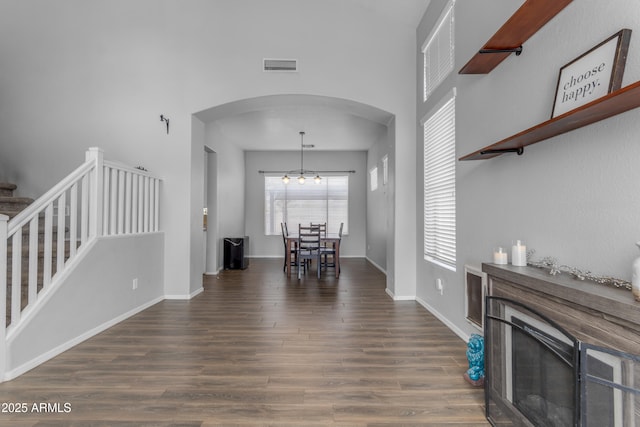 1405 S Honeysuckle Cir, Gilbert, AZ 85296 - living room featuring arched walkways, wood finished floors, stairs, baseboards, and a glass covered fireplace