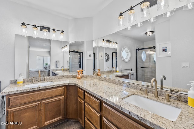 bathroom with a stall shower, double vanity, and a sink