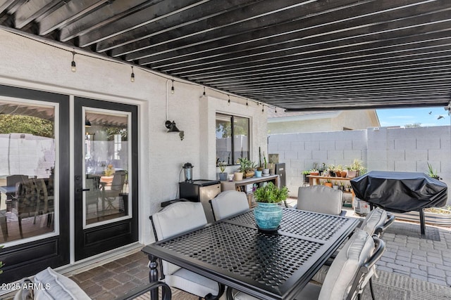 view of patio featuring a grill, fence, and outdoor dining area
