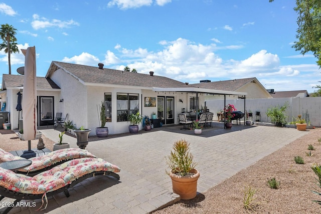 back of house with fence, a patio, and stucco siding