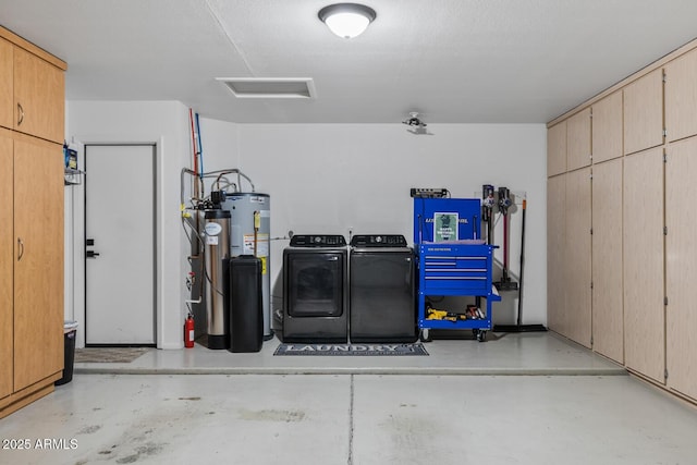 garage featuring washing machine and dryer and water heater