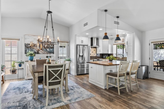dining area featuring an inviting chandelier, visible vents, a wealth of natural light, and dark wood-style flooring