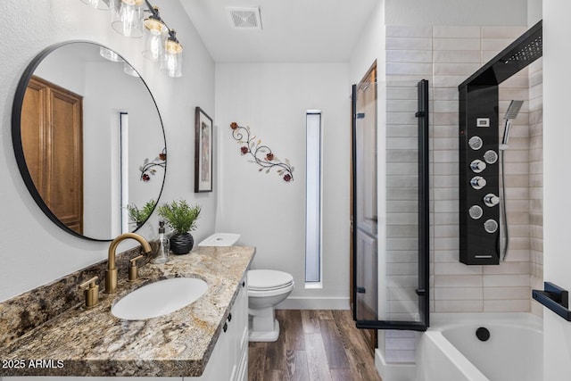 full bathroom with toilet, a shower with shower door, visible vents, and wood finished floors