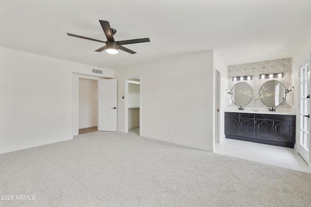 interior space featuring visible vents, a ceiling fan, connected bathroom, carpet flooring, and baseboards