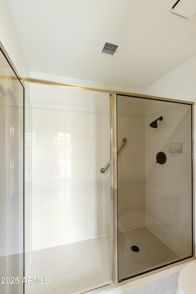 bathroom featuring visible vents, a shower stall, and toilet