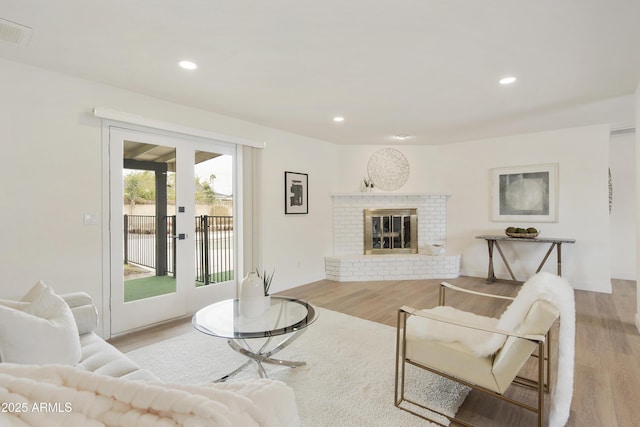 living room featuring recessed lighting, visible vents, and wood finished floors