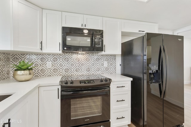 kitchen with black appliances, white cabinets, and light countertops