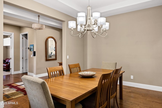 dining area featuring dark wood-type flooring and a notable chandelier