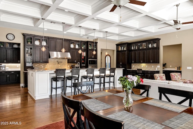 dining space with coffered ceiling, beam ceiling, dark hardwood / wood-style floors, and ceiling fan