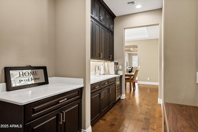 kitchen with dark hardwood / wood-style floors, sink, and dark brown cabinetry