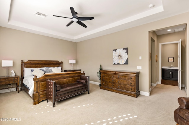 carpeted bedroom with ceiling fan and a raised ceiling