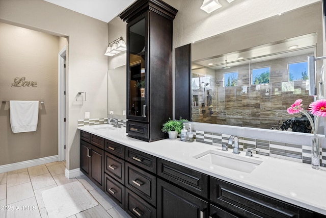 bathroom with vanity, tasteful backsplash, and a tile shower