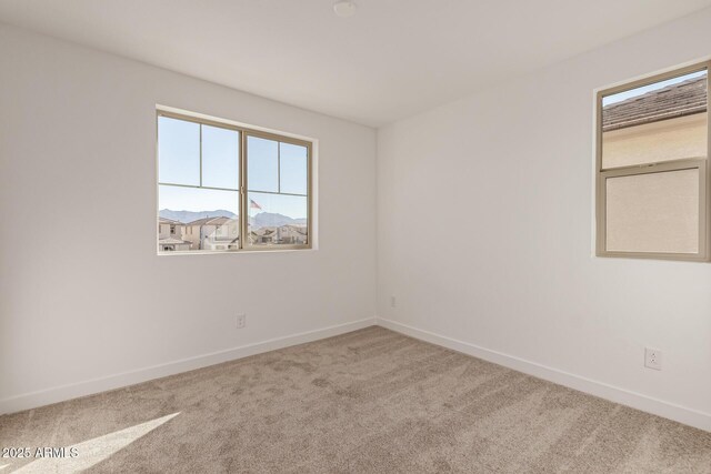 unfurnished room featuring baseboards and carpet flooring