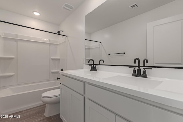 full bathroom featuring wood tiled floor, visible vents, a sink, and shower / bathtub combination