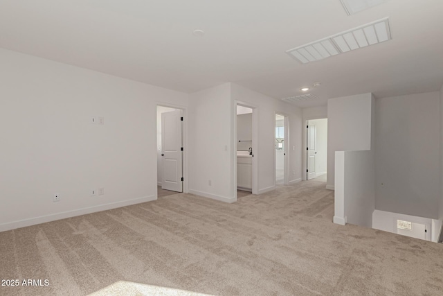 unfurnished room with baseboards, visible vents, and light colored carpet