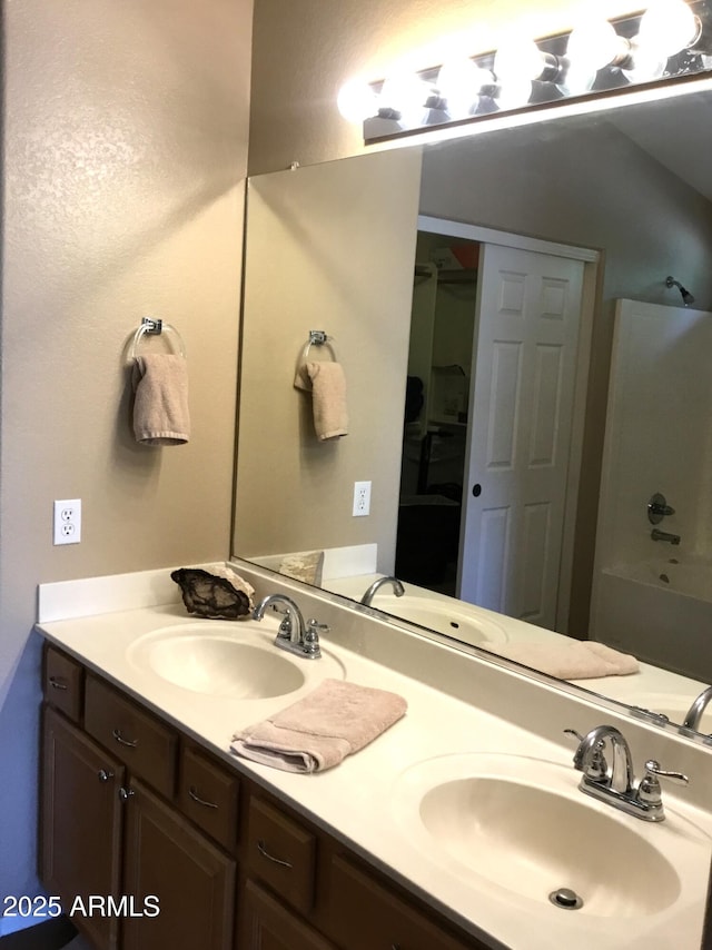 bathroom featuring vanity and  shower combination