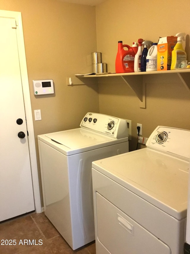 clothes washing area featuring dark tile patterned floors and separate washer and dryer