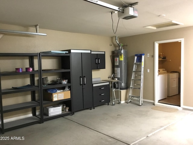 garage with a garage door opener, washer and clothes dryer, and gas water heater