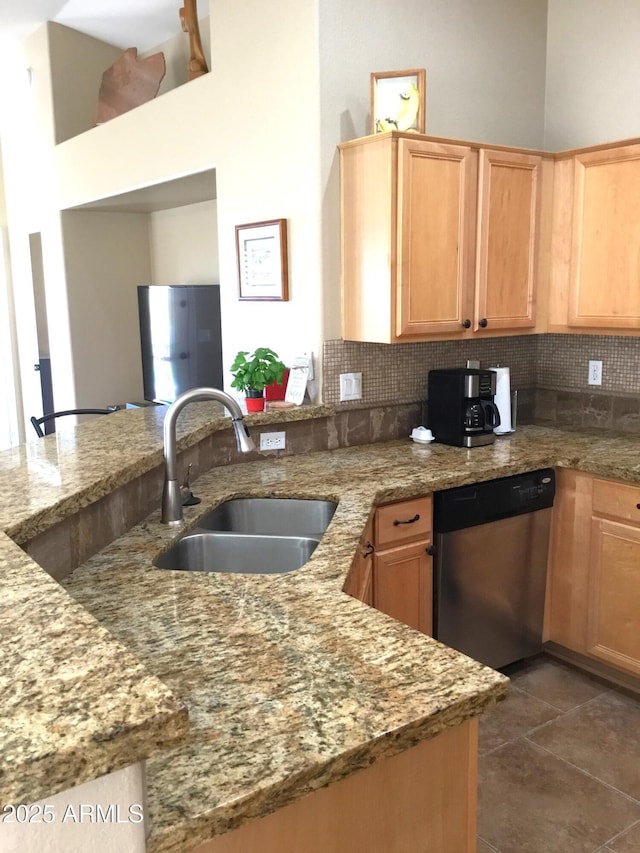 kitchen featuring kitchen peninsula, light stone countertops, dishwasher, and sink