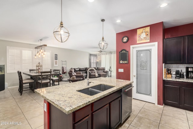 kitchen featuring pendant lighting, dishwasher, sink, an island with sink, and a chandelier