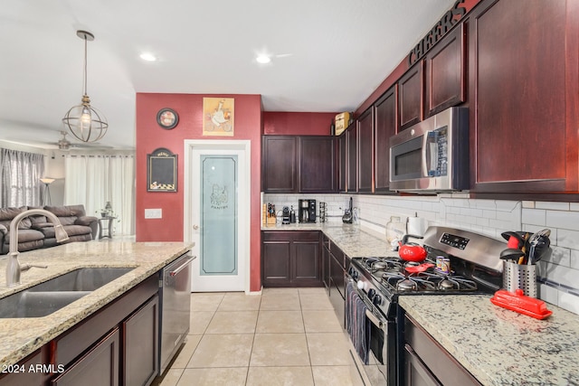 kitchen with light stone countertops, sink, tasteful backsplash, light tile patterned floors, and appliances with stainless steel finishes